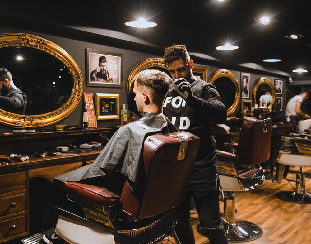 Barbero atendiendo a un cliente en una barbería